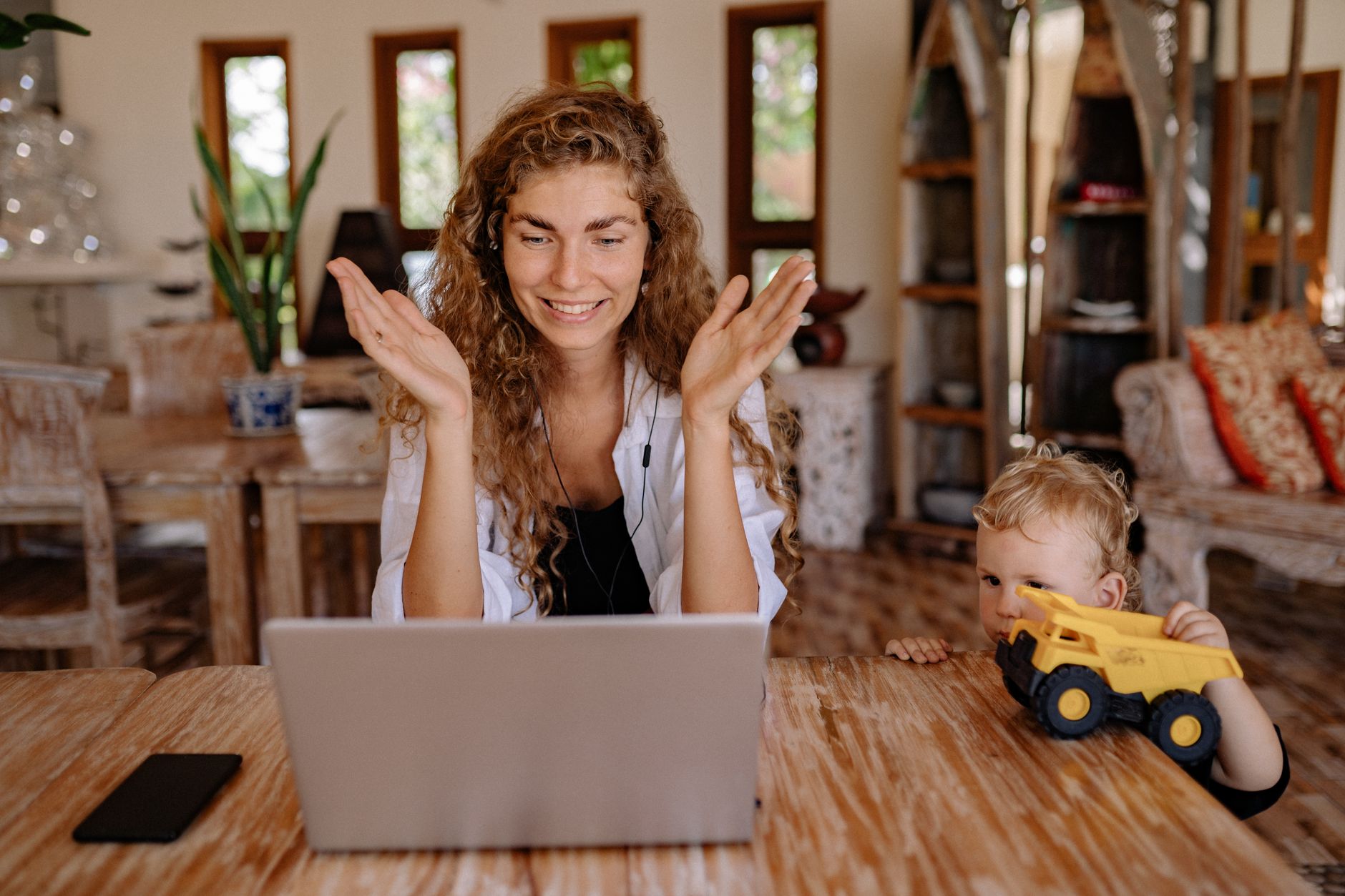 Mama z dzieckiem na kanapie prowadzą wideorozmowę na laptopie